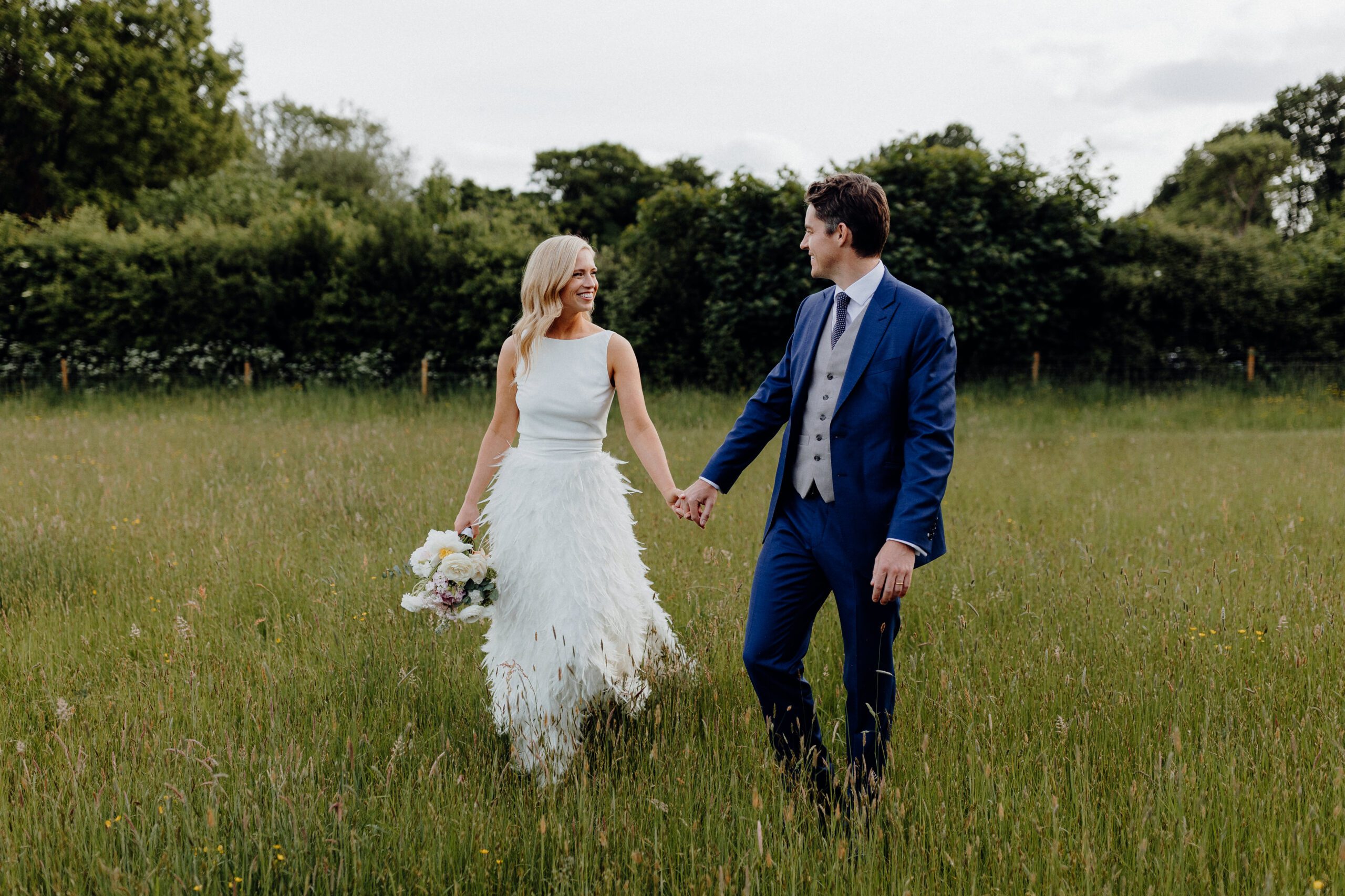 Couple walking through field at New Barn Farm on their wedding